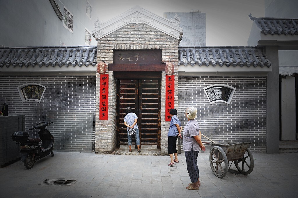 海口市府城老街新建的一家“老宅子咖啡“即将开张，三位老太太路过，很好奇的探头张望。