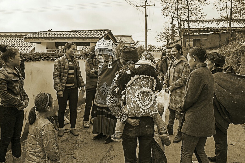 人们都围拢过来看新嫁娘,一身大红的彝家新娘装,配上闪闪的银饰,非常漂亮
