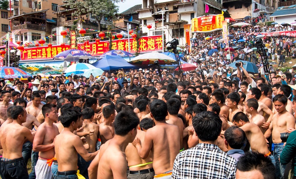 人们按照村落组成团队,全部裸露上身,奔跑在降落点争抢[花炮]