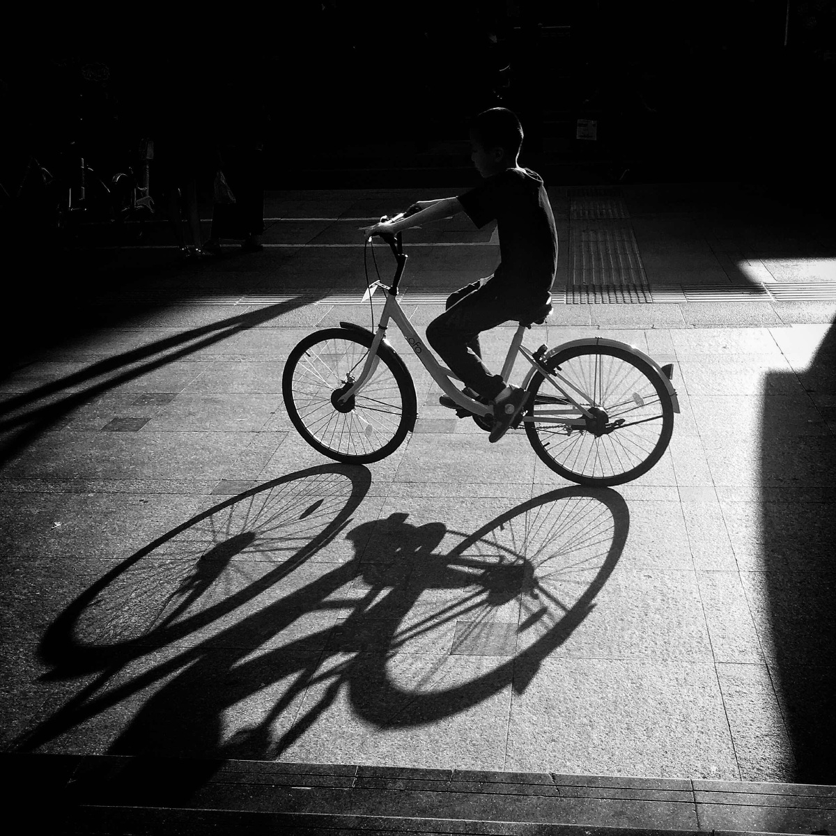 街道上来去匆匆的行人在夕阳下留下长长的影子