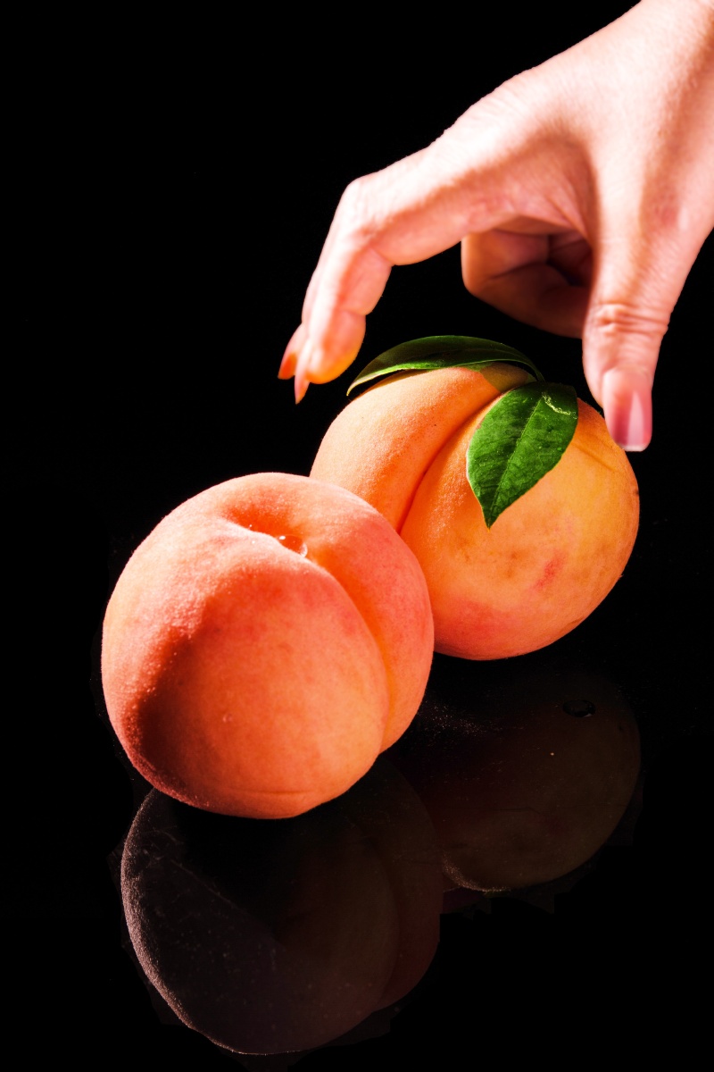 桃子挑软的捏黑色背景下的特写镜头