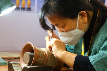 进博会上，非遗传承人韩长霞在展会现场为观众展示“潍坊嵌银”技艺。光明日报记者郭俊锋摄