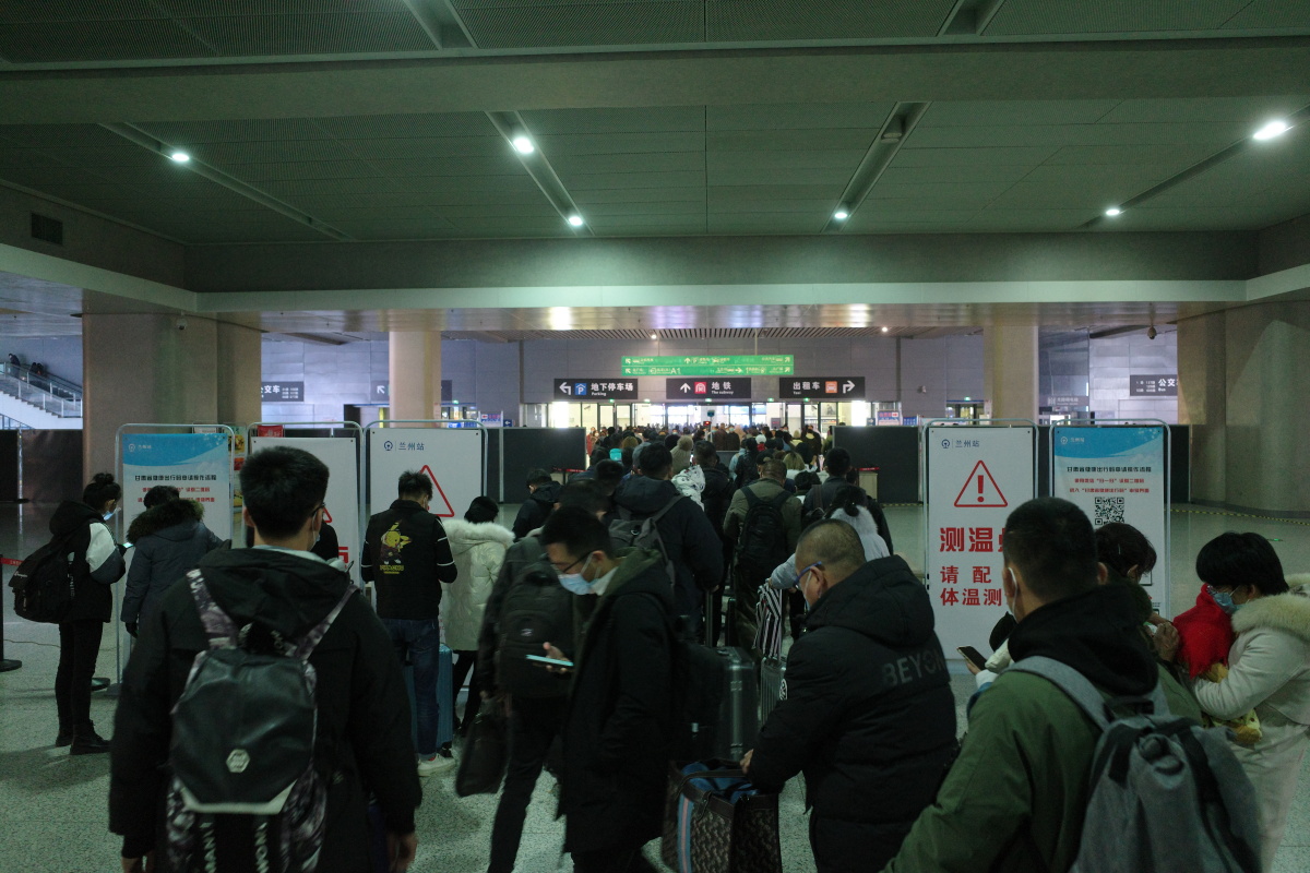 高铁站出站口,旅客们挤作一团在扫描二维码通关.