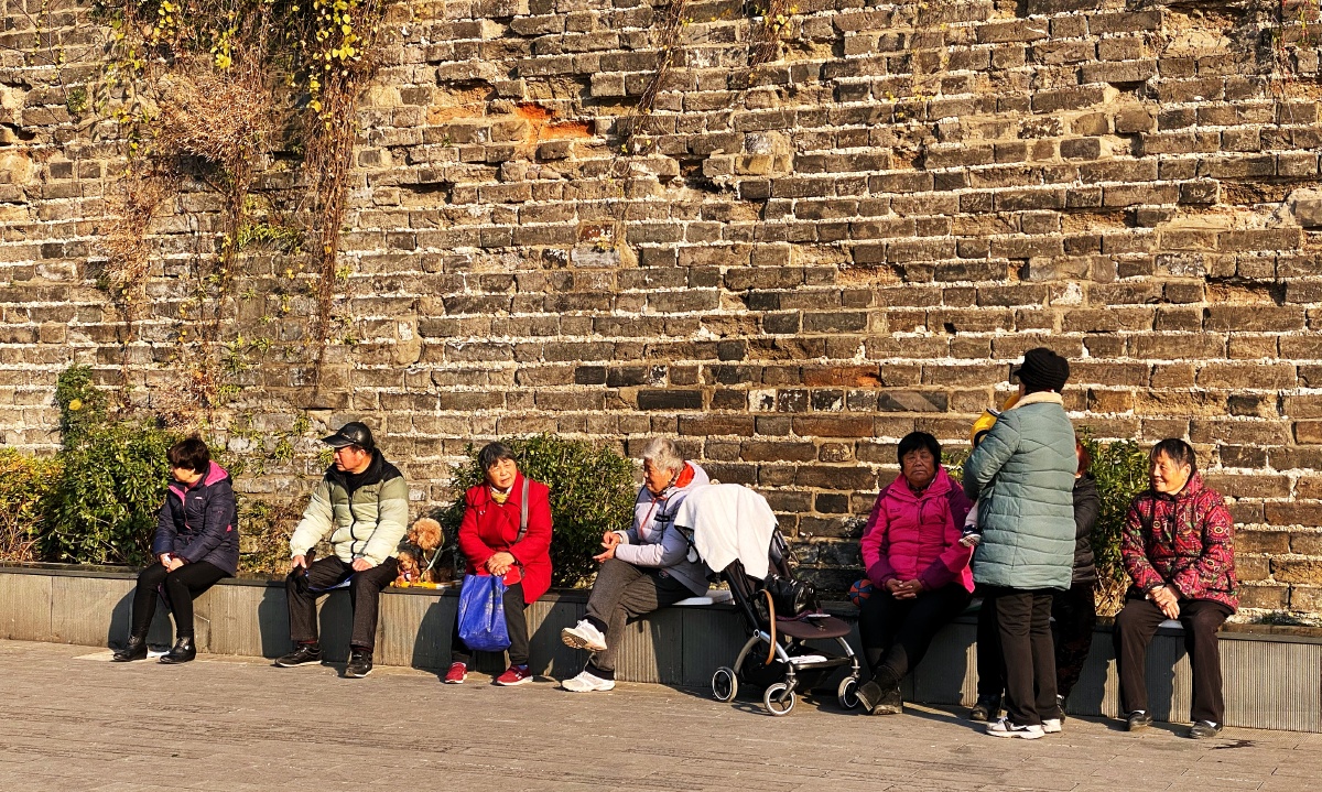 城墙根晒太阳的人们