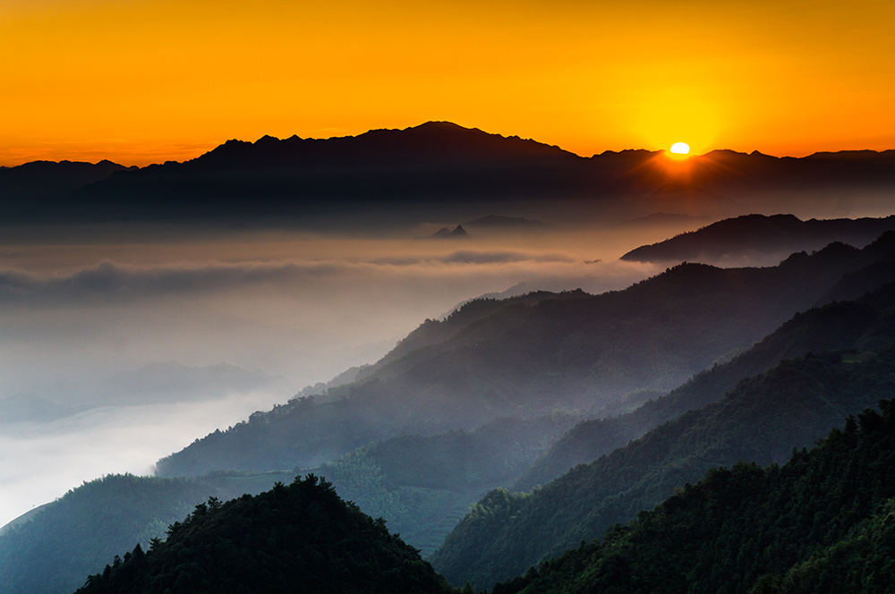 一轮红日喷薄而出,映照着连绵群山.