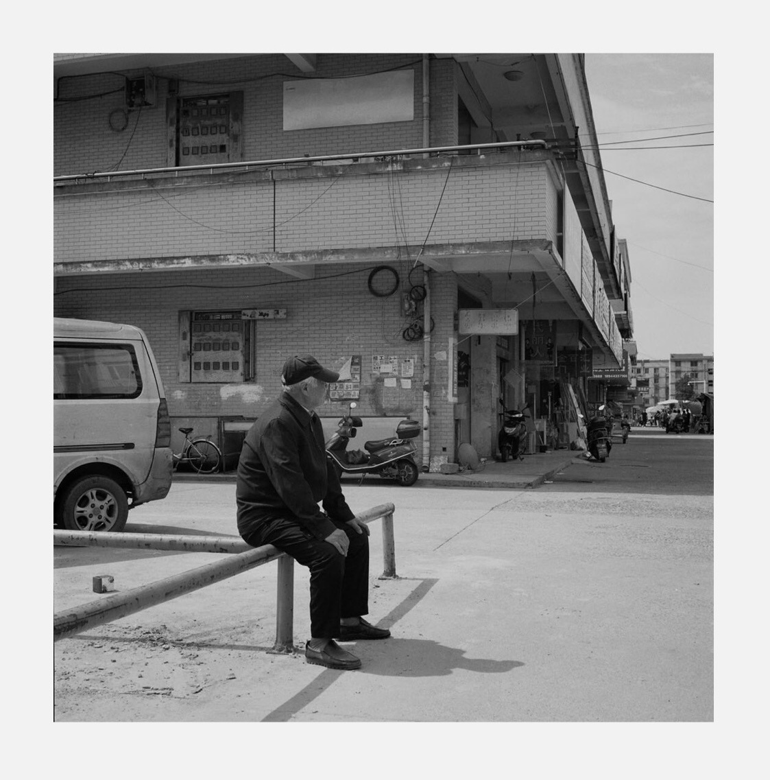 孤独一个坐在市场铁架子上的老人