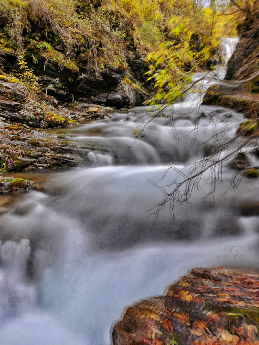 秋日美丽的小溪流就像是一条银光闪烁的绸带给美景如画的山谷镶上了一