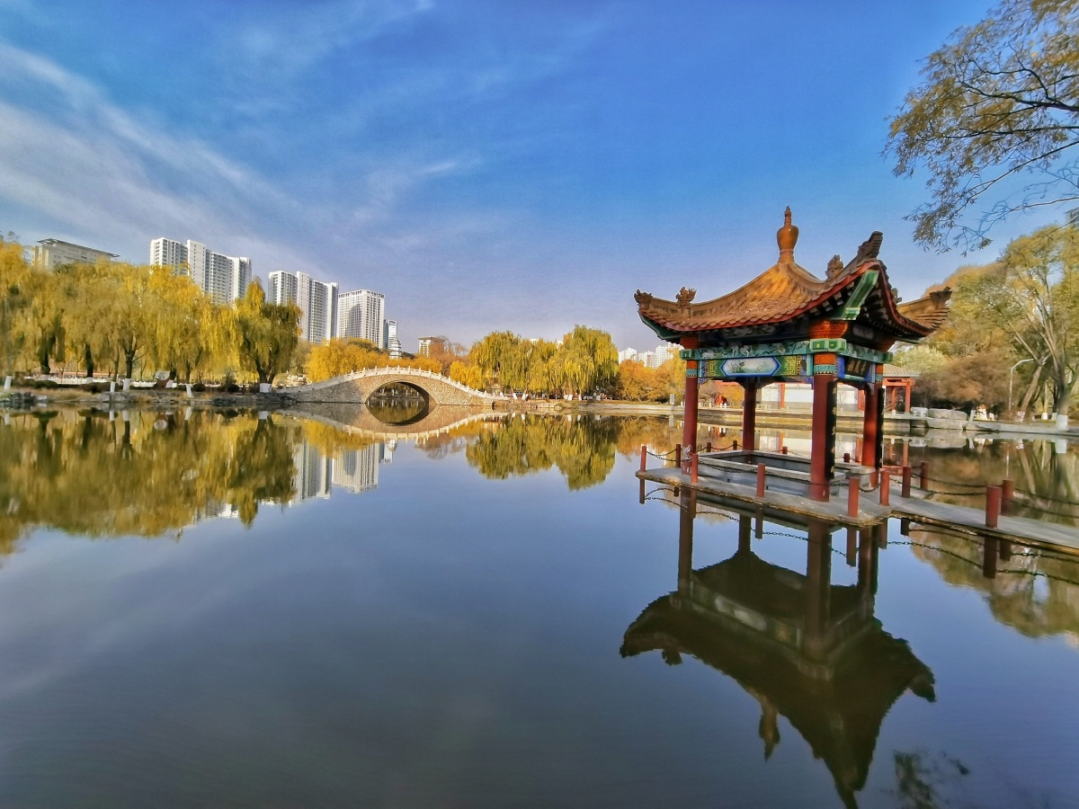 秋日的西宁人民公园风景如画,阳光色调恬淡,湖面平静得