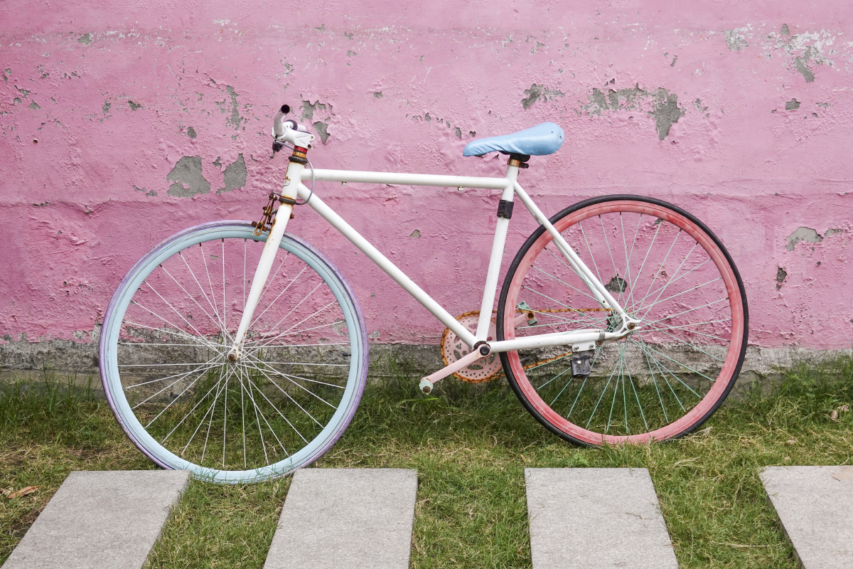 粉色墙壁停靠的彩色自行车