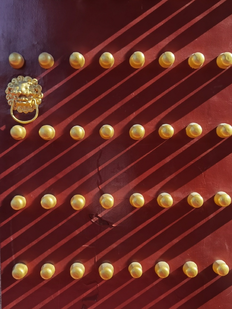 光影下的朱漆大门