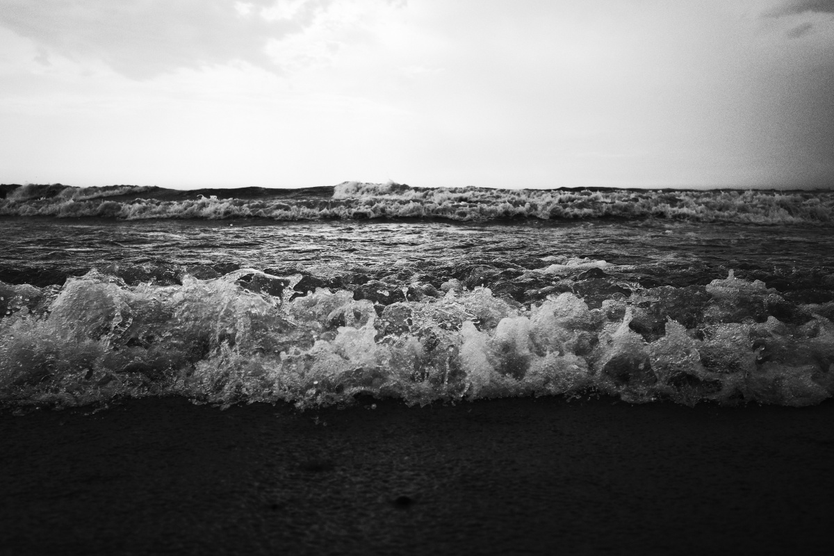 心情不好的时候在多云的海边,孤独的人,腐烂的死鱼和不断拍打海岸的