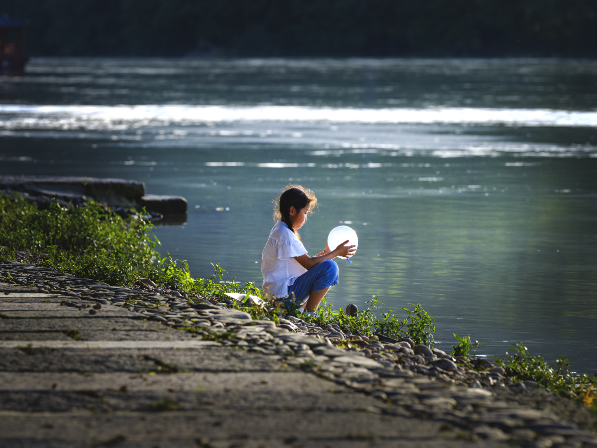 街拍河边小女孩气球
