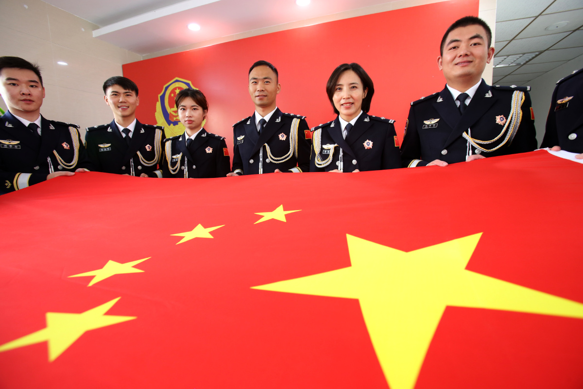 江苏连云港穿上首次配发的警礼服与国旗合个影