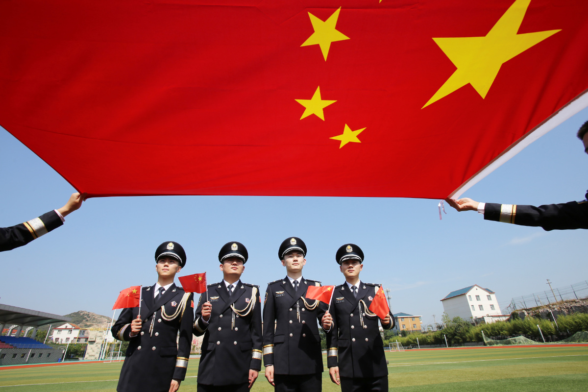 江苏连云港穿上首次配发的警礼服与国旗合个影