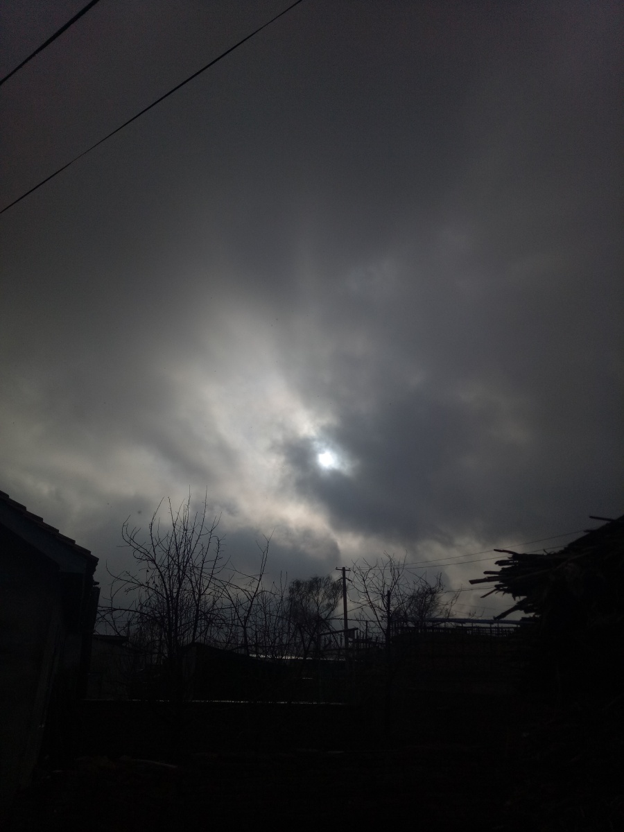 下午四点半的天空在乌云背后的太阳透着光亮