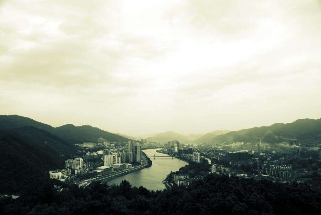 故乡四面环山，一条大河分割两岸。也划分了城市功能的界限。一边是生活区，一边是工业区。当代的商业建筑，旧时的苏联痕迹的烟囱厂房，不免产生时光的错觉。