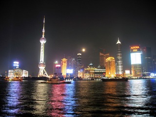 a上海浦东陆家嘴东方明珠璀璨的夜色，黄浦江上游船在经过