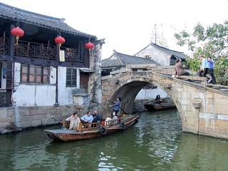 周庄集中国水乡之美，是中国第一水乡，小桥流水人家是水乡的特色，一艘小船从石拱桥下经过