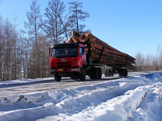 大兴安岭森林冬季，冰雪公路上行驶的运材（运输木材）的卡车。