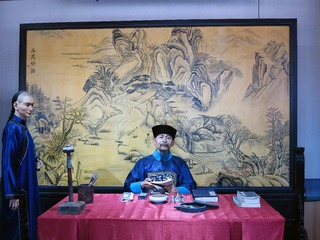 率性堂场景，是国子监的高级班，有助教和学正两位老师。学生恭敬站在老师身侧，向老师请教问题。如果学生对老师的讲授有质疑，为表示尊敬，学生则要跪在老师面前提出疑问。北京孔庙和国子监博物馆。