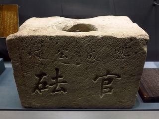 上书“恩成公柜官砝”的石质官砝，崇文区北五老茶商旧址出土，恩成公柜是旧时位于北京南城珠市口东大街路南的公盐柜，当时垄断全城的官盐销售。首都博物馆“古都北京”文物展。