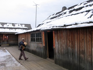 内蒙古额尔古纳市边境村庄太平川的华俄后裔家庭，民居院落，孩子在抱柈子。