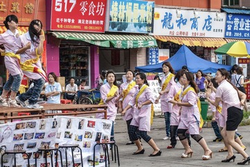 19  A1P4446 2010年5月22日，广东省东莞市。电子厂的打工者下班后参加美容培训，培训前先跳舞锻炼胆量，也为培训机构做活广告。