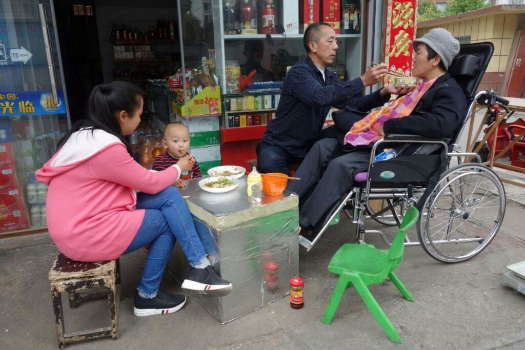 丈夫给瘫痪的妻子喂饭，儿媳为小孙子喂饭，真情满满。