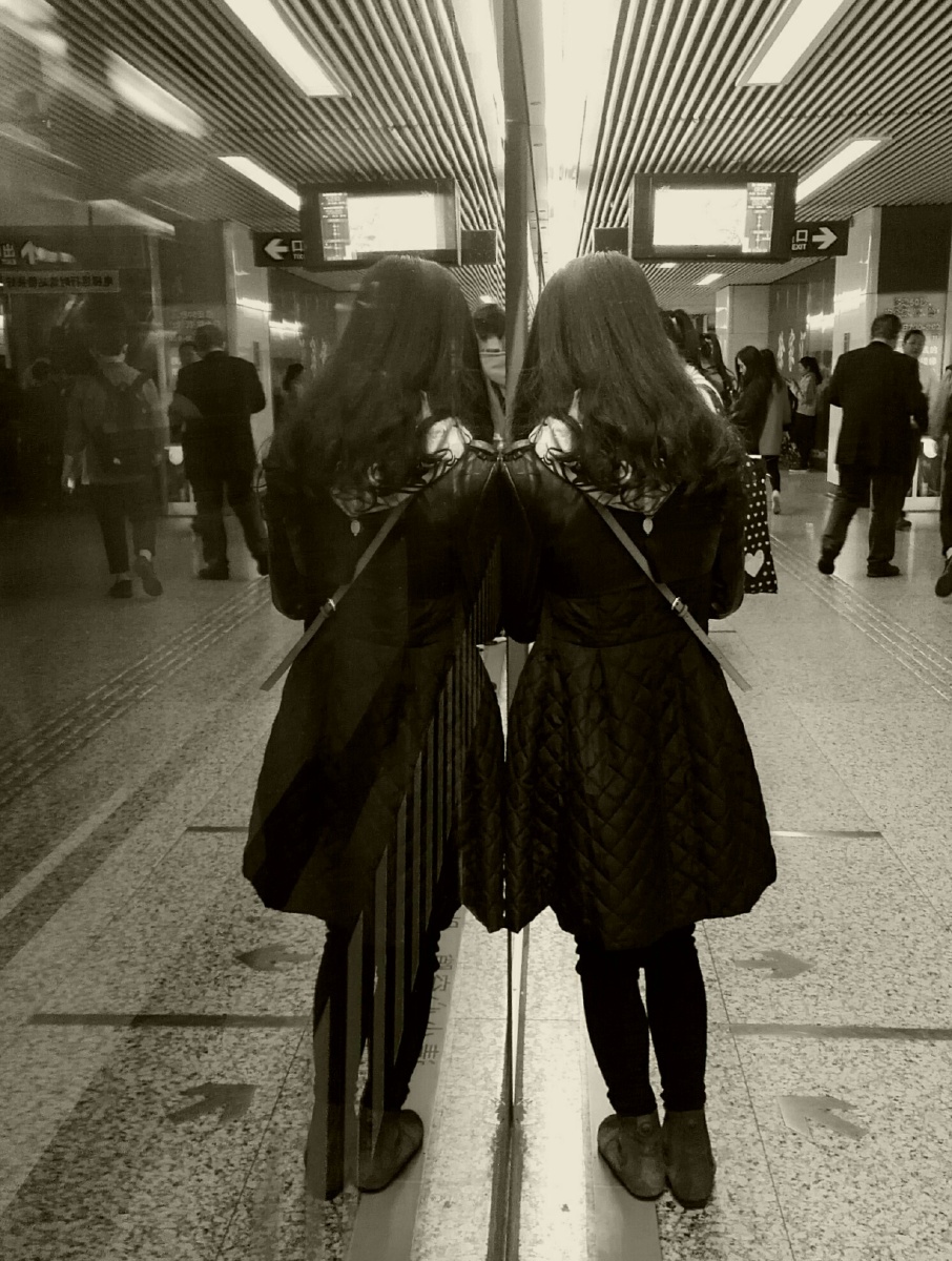 地铁刚刚开走,女孩子靠着玻璃隔断,a字裙,心型图案的围巾,美好的背 