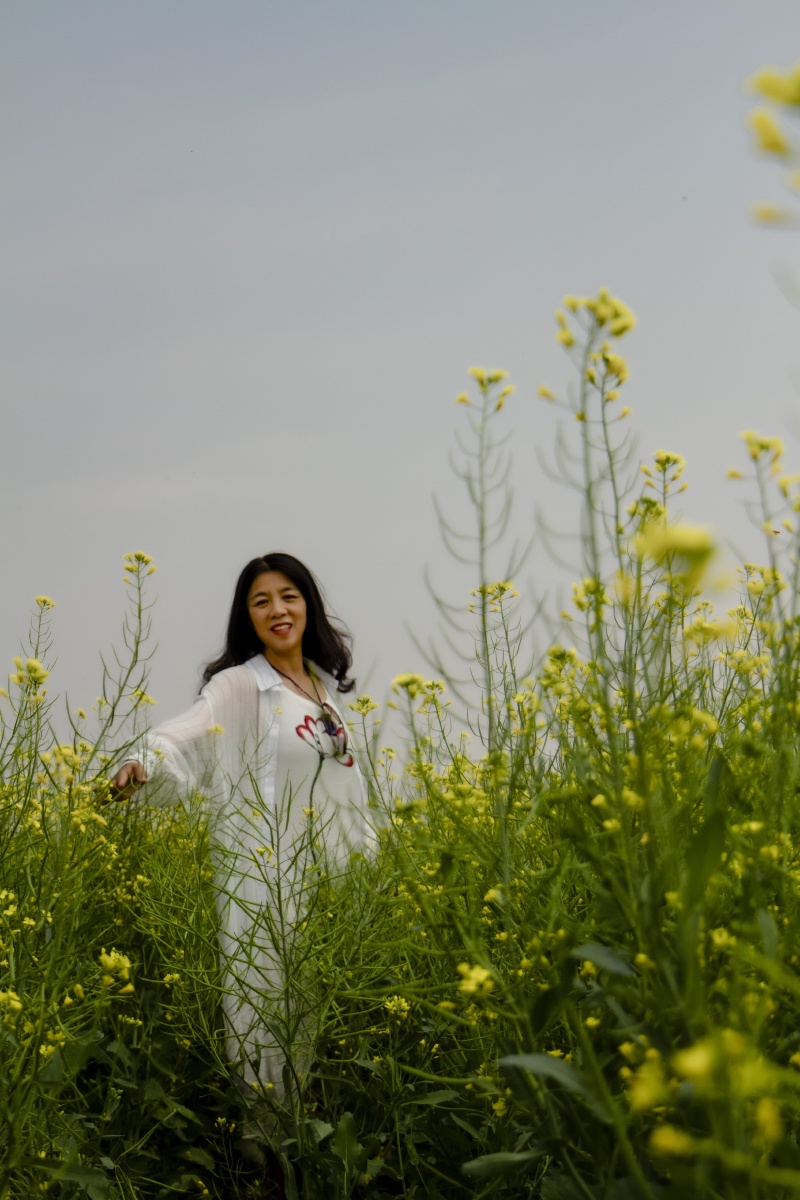油菜花田中的女人