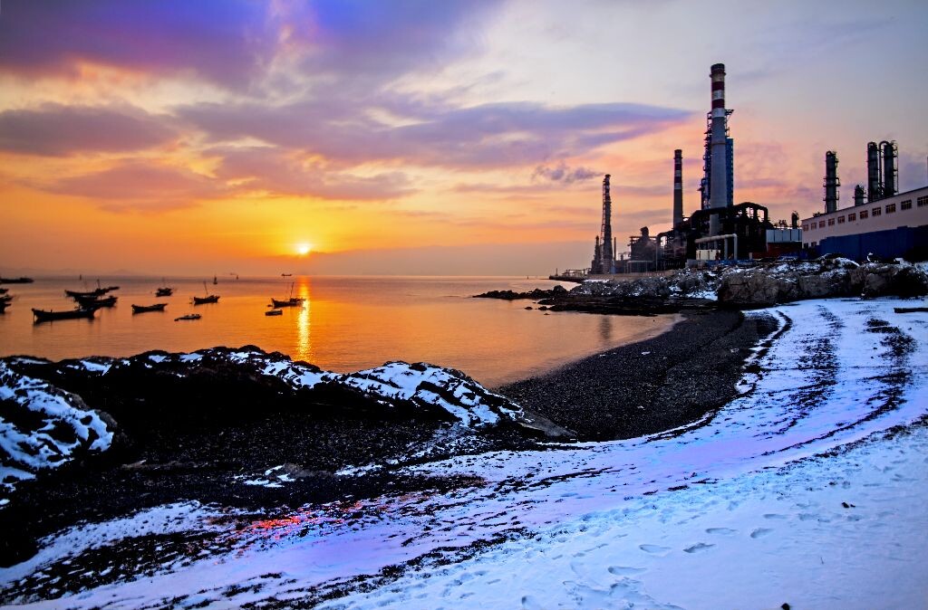 这是大连冬天的海。一夜大雪在沙滩上留下一片雪白。清晨，旭日升起，红霞万丈，映红了大海，也给白雪染上了一抹嫣红。
