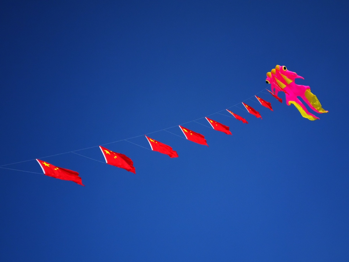 五星红旗迎风飘扬大年初一一位风筝爱好者在松花江哈尔滨市区段冰封的