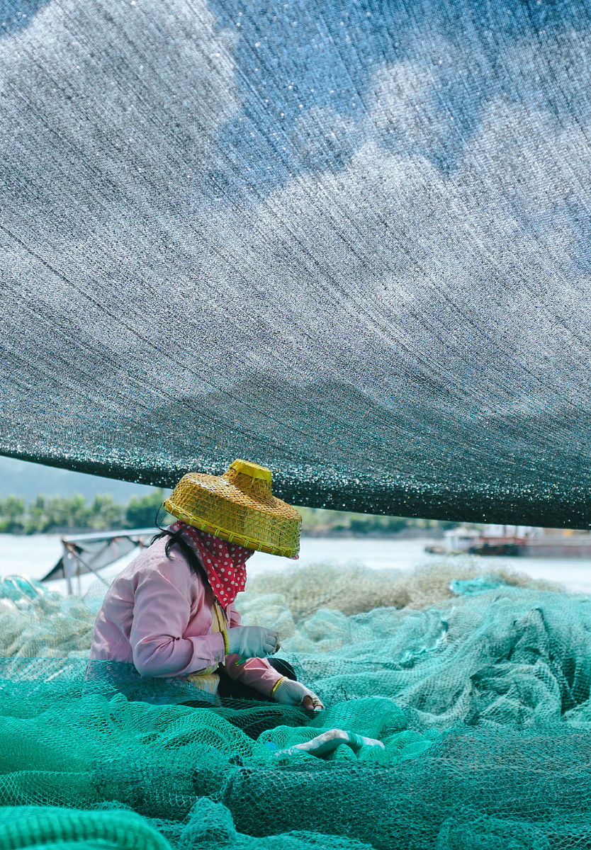 忙着织网的渔民