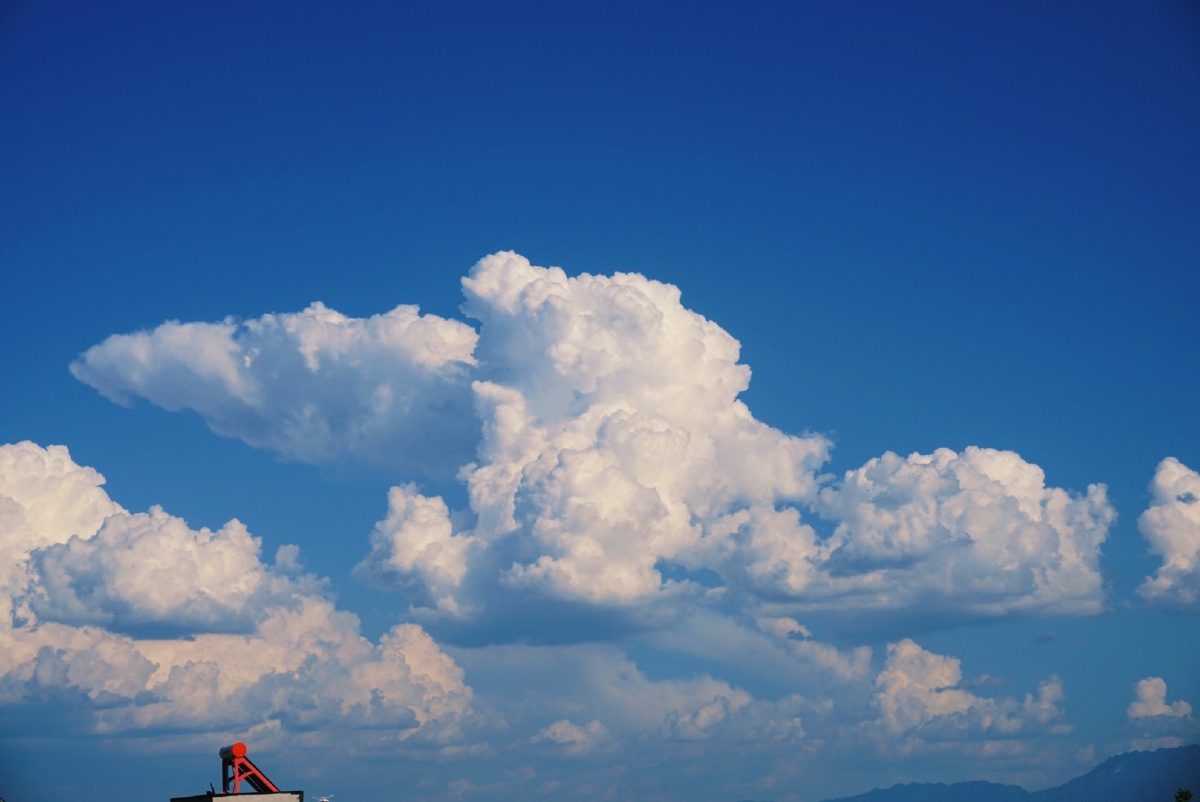 那天的云毫不吝啬是大朵大朵的堆砌在澄净的蓝天上在天空下面还有个