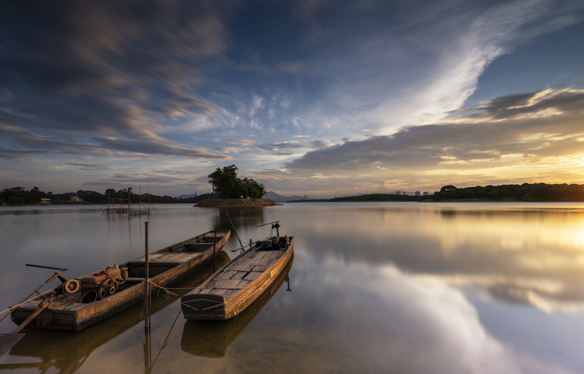 夕阳下的松山湖停泊的小舟被映红湖面宁静祥和