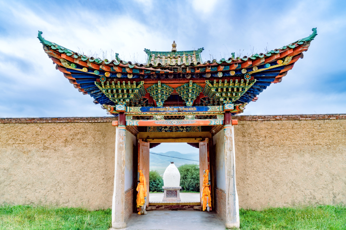 山谷中的金顶寺庙祁连山满山青草的山间一座金顶的藏族寺庙屹立其间