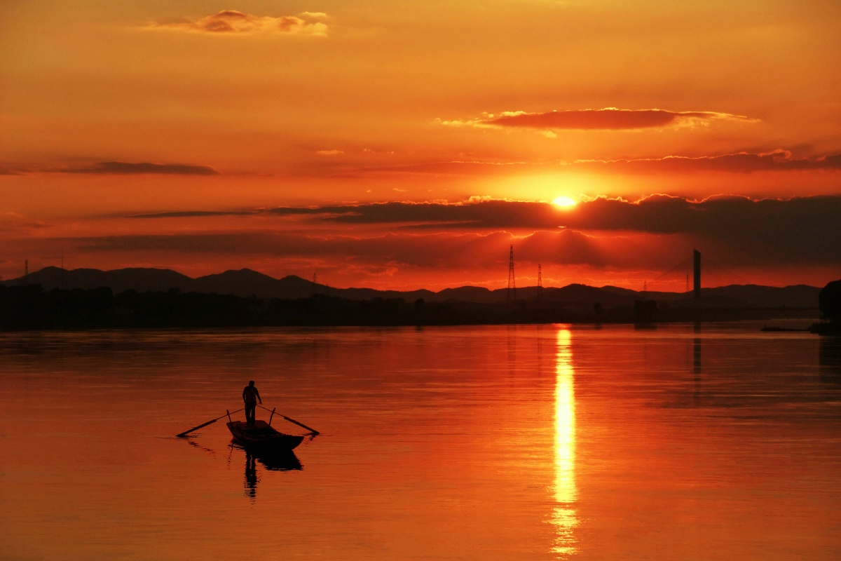 夕阳染水连天色渔舟泛波在黄昏