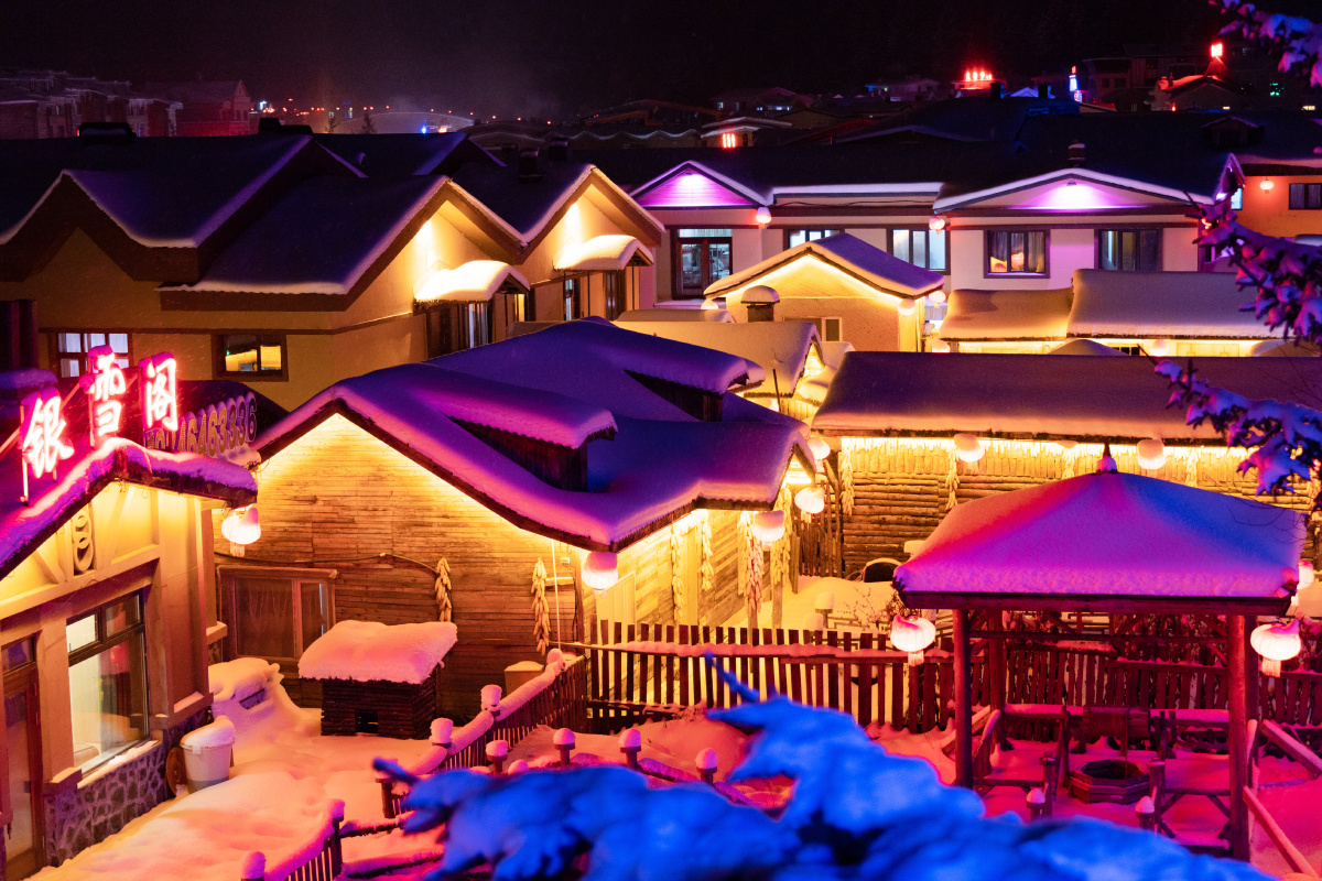 哈尔滨雪乡的夜景篝火晚会人群雪花