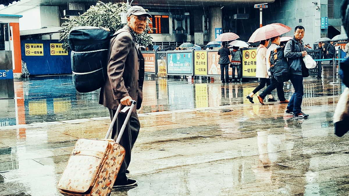 手机拍摄下雨时车站的人们
