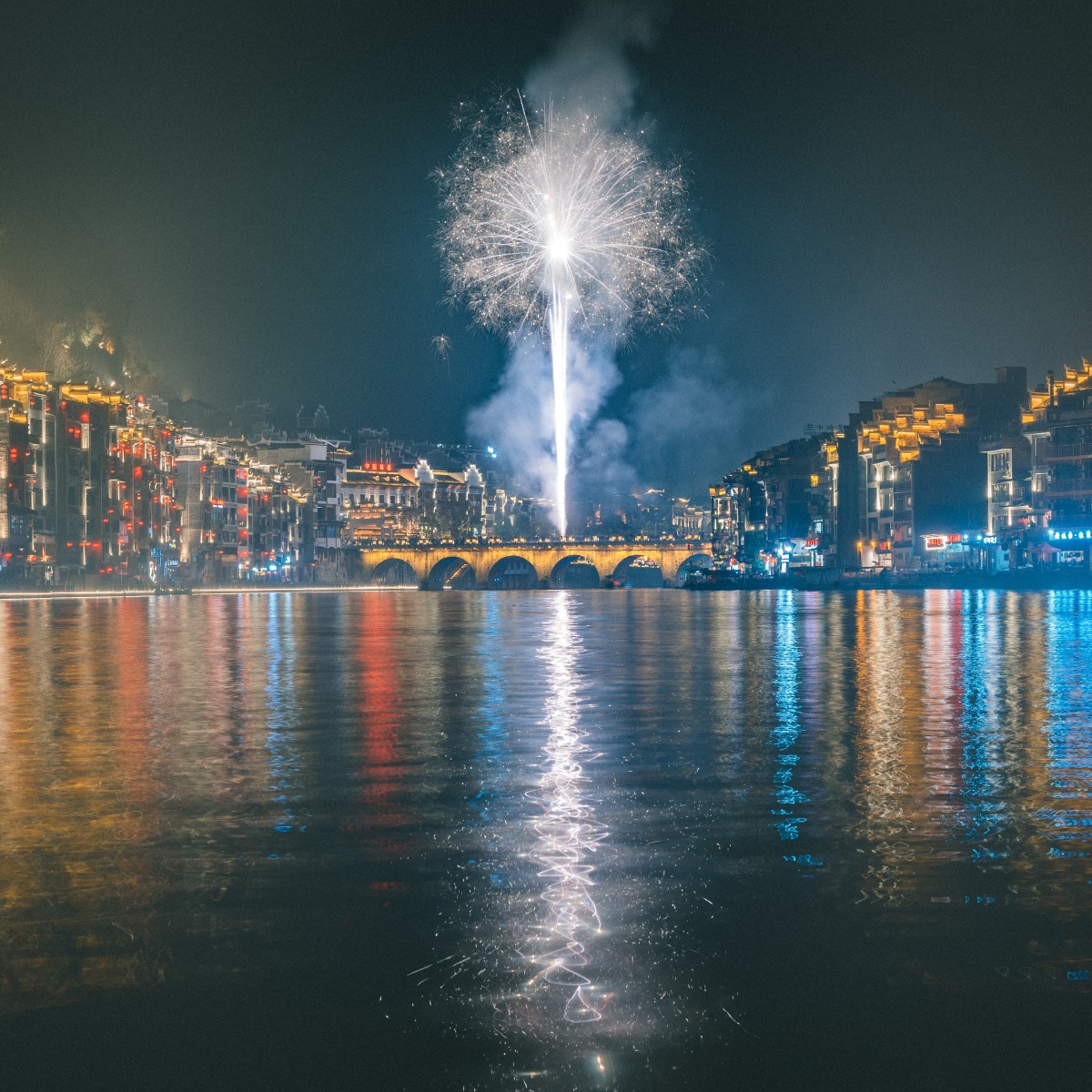 新年的夜晚古镇的桥头用相机抓拍到了白色的烟花