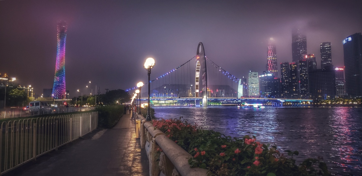 中国广州夜晚灯光色彩丰富的小蛮腰广州塔猎德大桥和城际列车