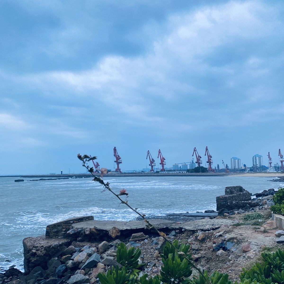 海南东方市鱼鳞洲海边傍晚时分吹海风喝啤酒远处海边有一位歌唱家在