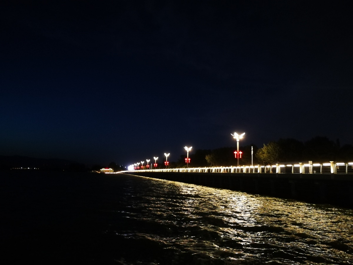 傍这徐徐微风走在滇池边赏着夜晚的美景