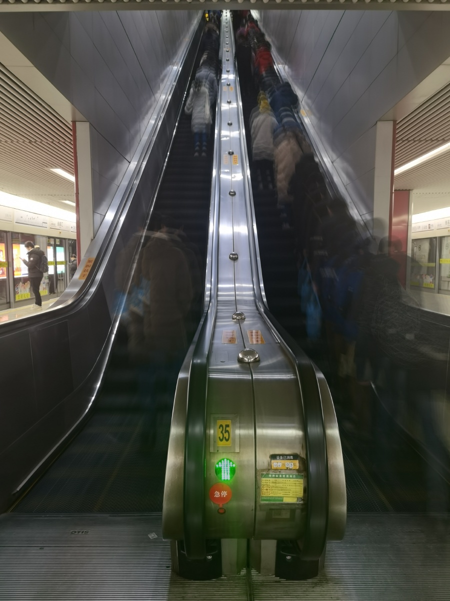 匆匆早晨8点地铁站里上班的人们匆忙地奔向各处长长的扶梯上有的人