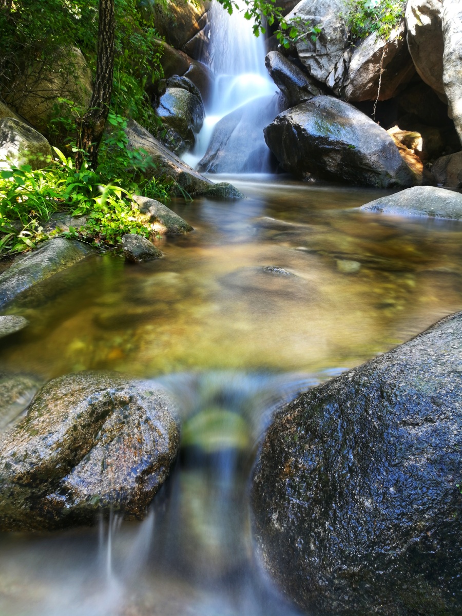 飞流直下的泉水如同两条白龙在水中嬉戏.