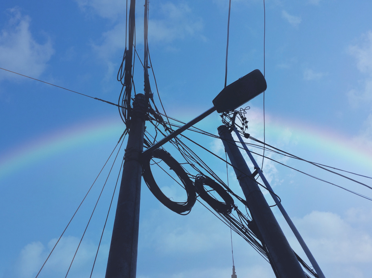 杂乱的电线杆后出现一道彩虹