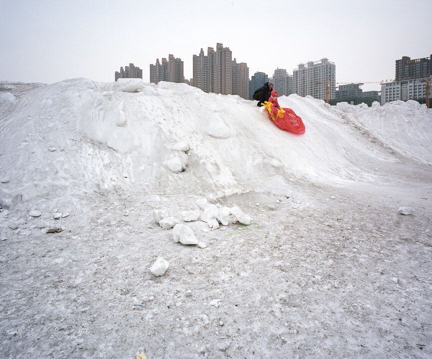 冰城<br />
冰城哈尔滨，市区的冰雪已经很难积累，这个广场因为堆放了清扫的积雪，成为了孩子们打雪滑梯的地方。
