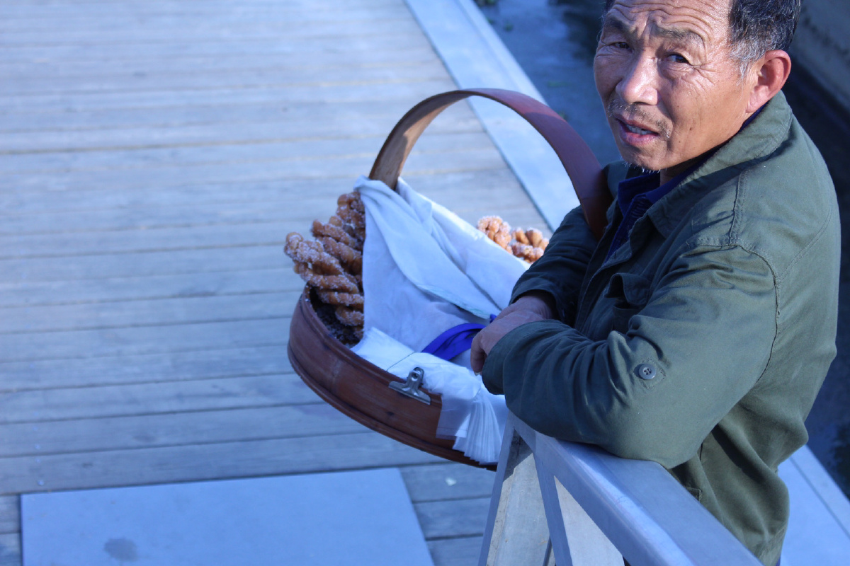 有很多买零食小贩,大爷挎着装满亮晶晶糖麻花的篮子,好几次望向我们