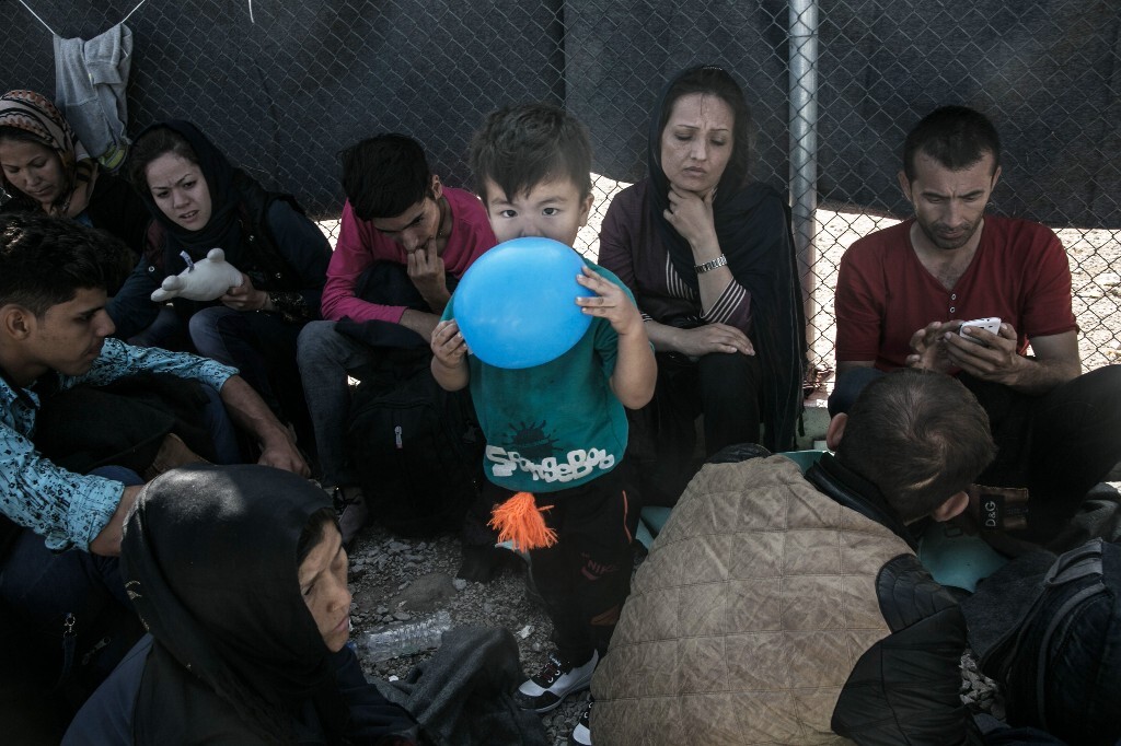 2015年10月19日，希腊莱斯沃斯岛，亚扎一家在难民营门口等待排队，亚扎的妻子莫雅已经有了5个月的身孕。