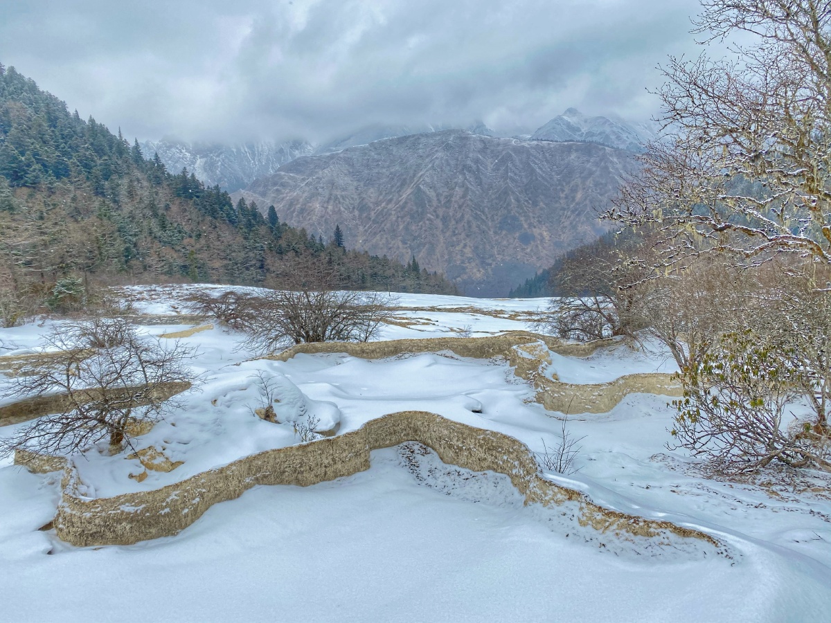 冬季的黄龙大部分的美被低温凝固大雪覆盖但春的气息仍然扑面而来解冻